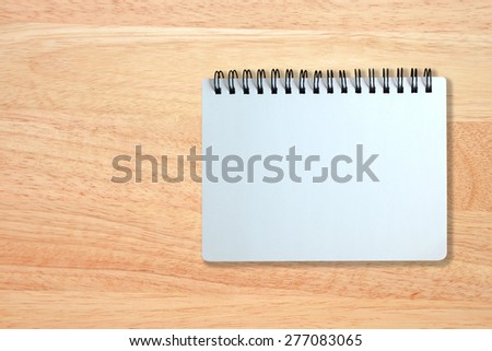 white page of notebook on wood texture background