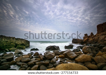 Waves crashing on rocky shore in dawn
