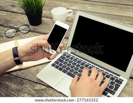 Businessman working on a wooden table with office supplies