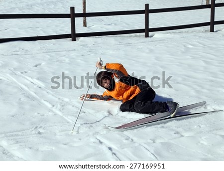 inexperienced boy trying for the first time the cross-country skiing and then he falls on snow