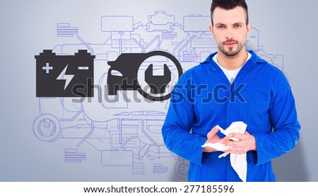 Mechanic wiping hands with cloth against grey vignette
