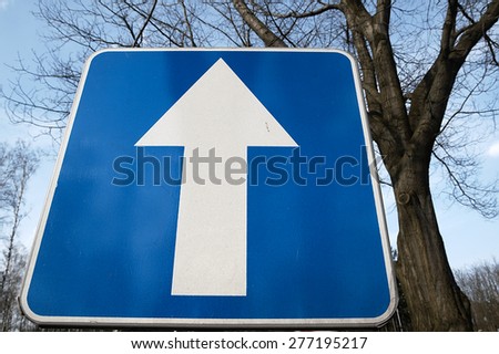 One-way traffic sign standing on the road.
