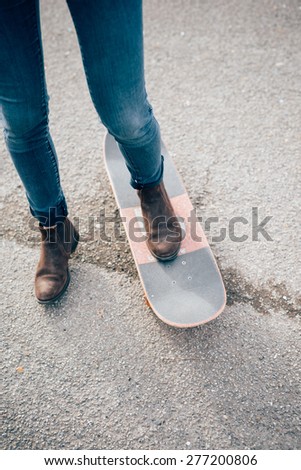 close up legs jeans of young beautiful hipster sporty blonde woman in town with skate
