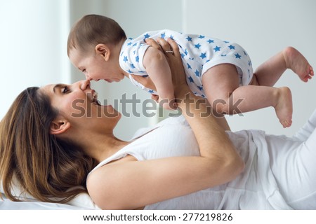 Portrait of mother and baby playing and smiling at home.