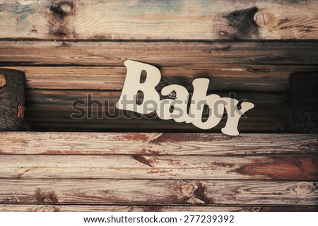 The inscription on the wooden background baby