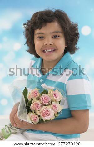 Little child holding bouquet of roses flowers on blue background