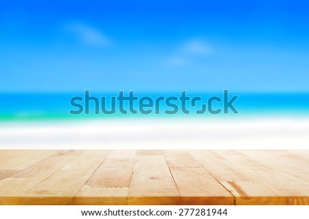 Wood table top on blurred beach background, summer concept  - can be used for display or montage your products