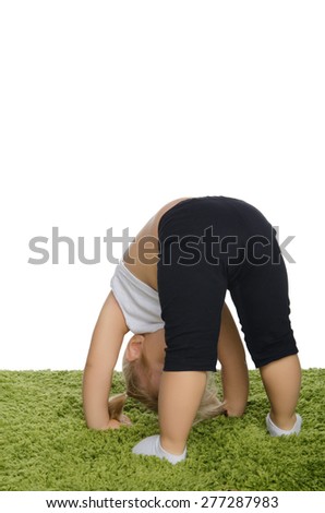 Little girl practicing gymnastics on green carpet