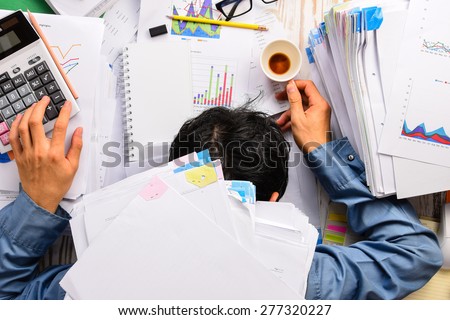 Businessman heavy workload sleep at office desk with finance sheet calculator and coffee.(concept for overworked) Royalty-Free Stock Photo #277320227