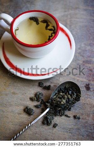 Cup of green tea and Home word on the old wooden background