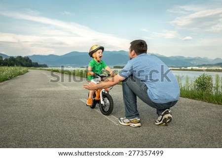 Father and son on the bicycle outdoor Royalty-Free Stock Photo #277357499