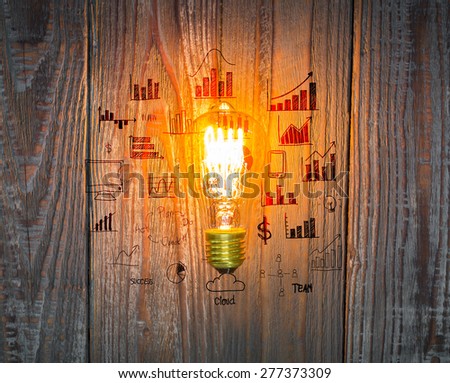 Glowing bulb with drawing graph on the wood background