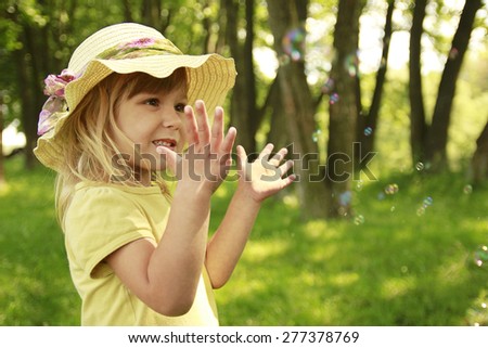 beautiful little girl in a hat on the nature
