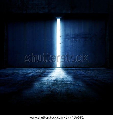 Light coming in through opening of heavy steel doors .Large metal doors of an hanger like building opening and blue light coming in. Royalty-Free Stock Photo #277436591