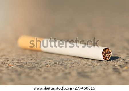 Closeup photo of a cigarette on asphalt