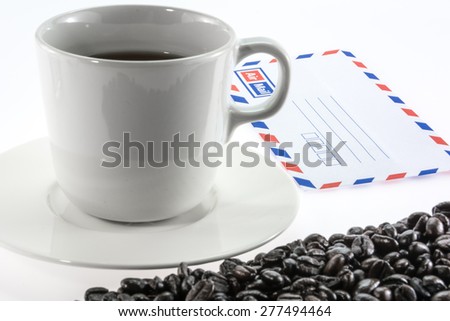 Cup of coffee and coffee beans with airmail envelope