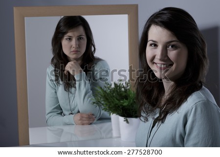 Lonely young woman with bipolar personality disorder Royalty-Free Stock Photo #277528700
