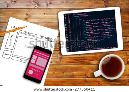 website wireframe sketch and programming code on digital tablet Royalty-Free Stock Photo #277550411