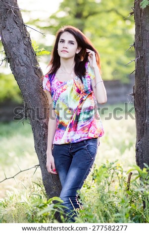 Beautiful girl posing in the park. Image has grain texture visible on maximum size