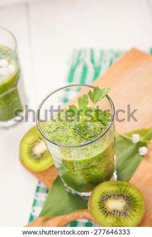 fresh green fruit smoothie in transparent glass in a studio