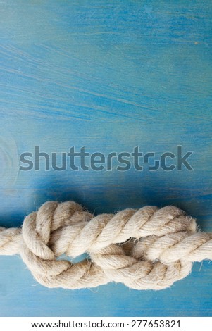 marine knot on blue wooden background with copy space