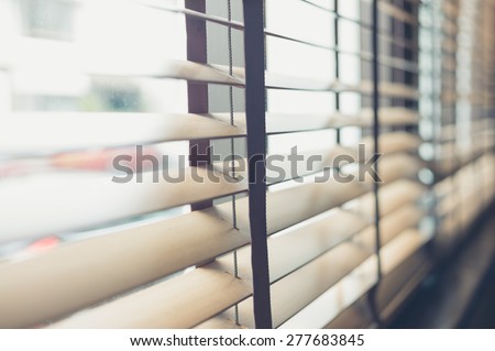 Sunlight coming through venetian blinds by the window Royalty-Free Stock Photo #277683845