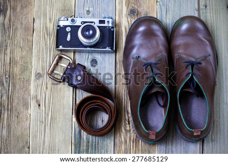 sturdy boots, leather belt, and rangefinder camera - set photojournalist on textured boards