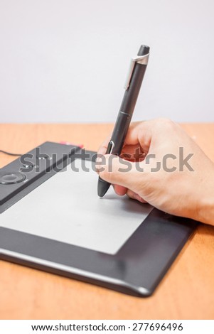 close up view of graphic designer hand using digital tablet pen and computer in the office studio isolated on white background. Modern professional technology concept