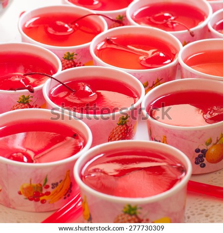 Cherry dessert arranged in paper cups.Focus on middle front cup.
