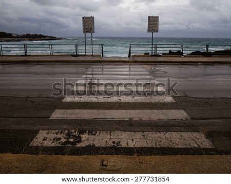 Zebra crossing on a coastal road shot in a rainy autumn day