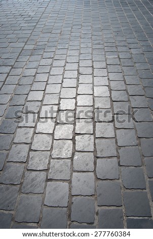 Old cobbled road in sunlight. Abstract texture for travel in Europe. Touristic background