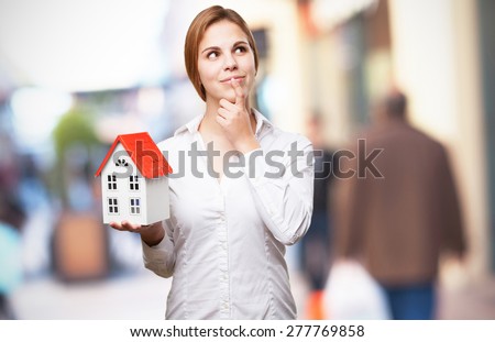 blond woman with a small house thinking
