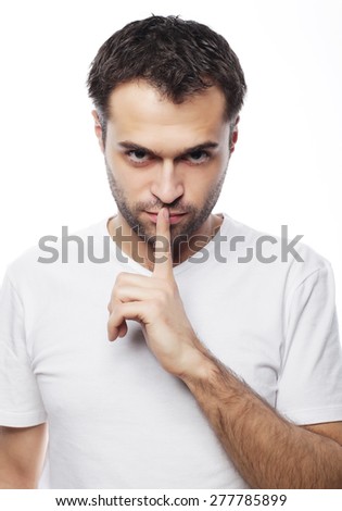 life style  and people concept: young man wearing white t-shirt making silence gesture, shhhhh!!