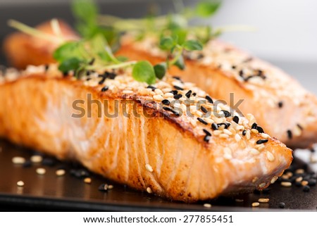 Grilled salmon, sesame seeds  and marjoram on a black plate. Studio shot Royalty-Free Stock Photo #277855451