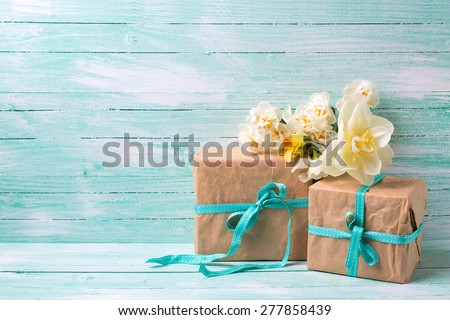 Festive present boxes  and flowers  on turquoise painted wooden background. Place for text. Selective focus.