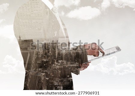 Businessman using his tablet pc against new york skyline