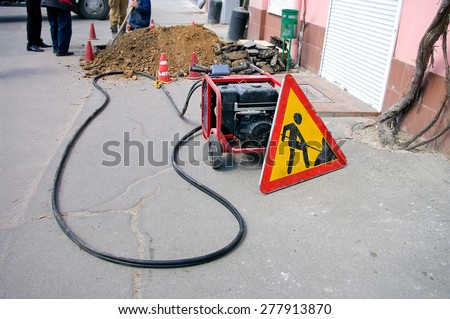 Sign and portable generator on road construction work in the city