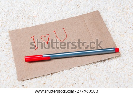 envelope and red pen on rice