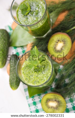 fresh green fruit smoothie in transparent glass in a studio