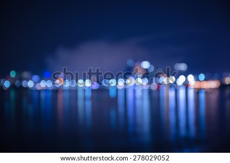 Colorful bokeh of city skyline from the sea in night time