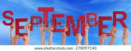 Many Caucasian People And Hands Holding Red Letters Or Characters Building The English Word September On Blue Sky