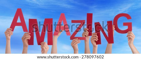 Many Caucasian People And Hands Holding Red Letters Or Characters Building The English Word Amazing On Blue Sky