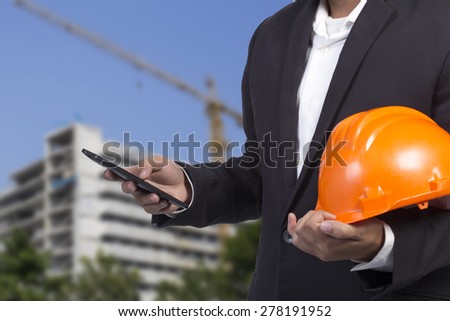 engineer checking emails on the phone on construction background