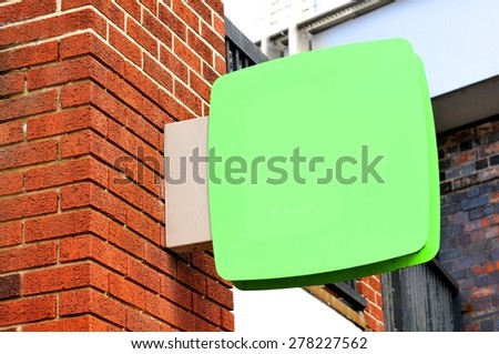 Blank sign against red brick wall