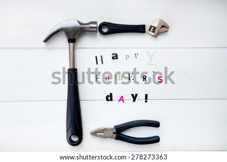 Happy Fathers Day Letters Cut out from Magazine and Tools On White Background