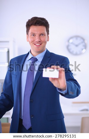 Portrait of young man holding blank white card, isolated