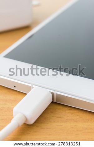 close up white smartphone is recharging