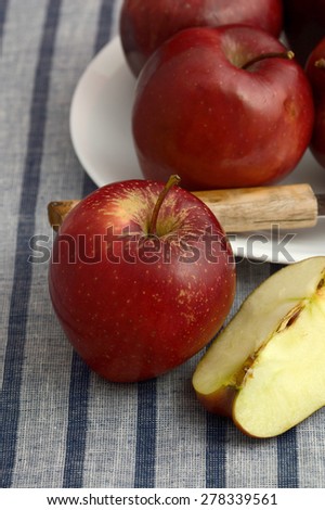 Delicious apples in white plate with knife on striped tablecloth
