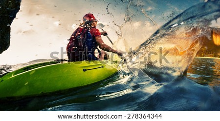 Young lady paddling hard the kayak with lots of splashes Royalty-Free Stock Photo #278364344
