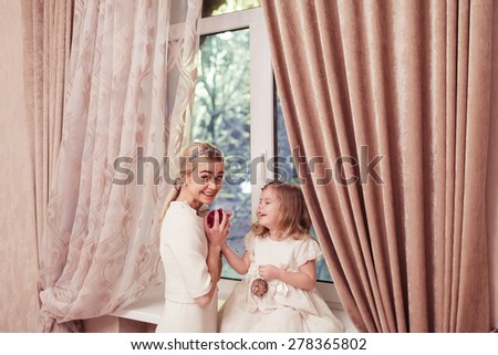 Happy daughter and mother over window